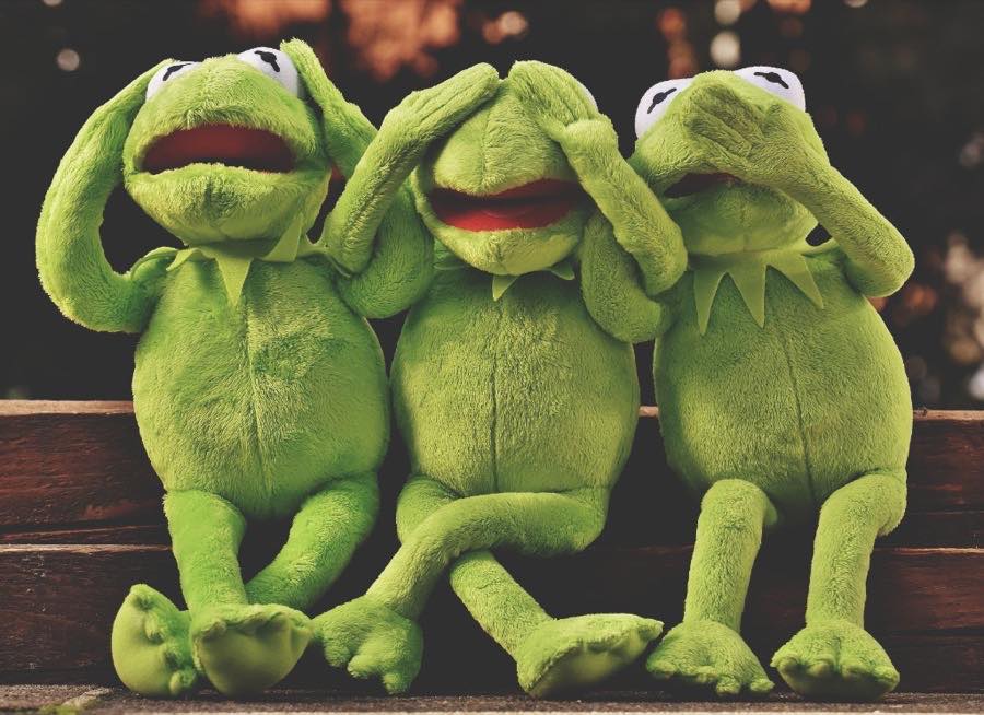 Three figures in hear no evil, see no evil, speak no evil poses