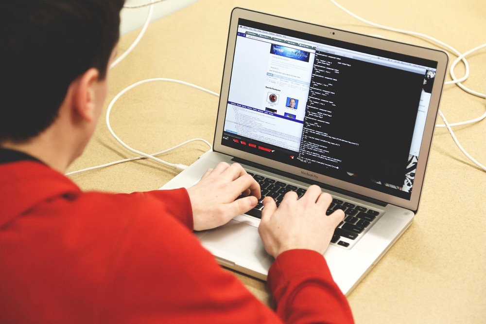 Developer working at a desk with a laptop open to code—where SSH key handoffs often start